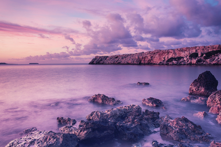 Beautiful colorful sunrise at the sea with dramatic clouds and boulders. Beauty world natural outdoors travel backgroundの写真素材