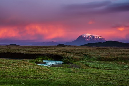 Beautiful volcanic mountain in Iceland covered with snow in pink sunset light