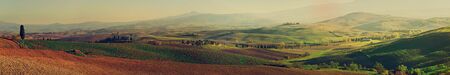 Wavy fields in Tuscany at sunset, Italy. Panoramic view. Natural outdoor seasonal autumn background.