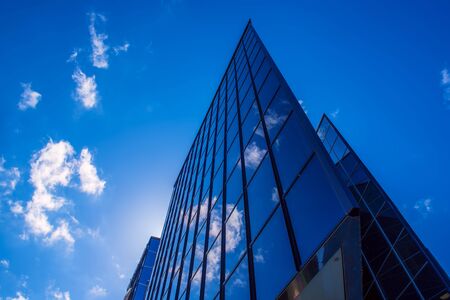 Abstract architecture background with blue sky and modern office building with reflection in the window glassの写真素材