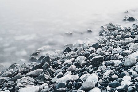 Dreamy natural background with sea shore, rocks and waves. Long exposure. Black and whiteの写真素材