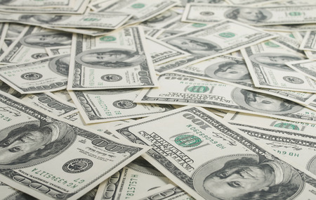 american dollars pile as background by hundreds of dollars bills