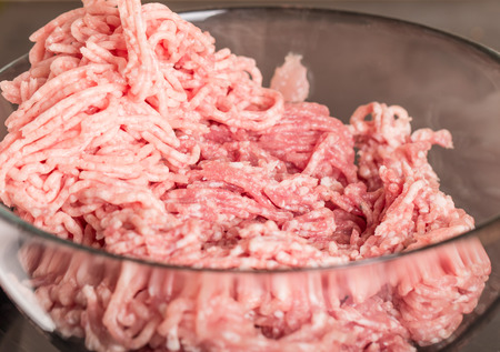 Mincer with raw chopped meat in plateの写真素材