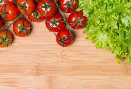Fresh lettuce and tomatoes on wooden backgroundの写真素材