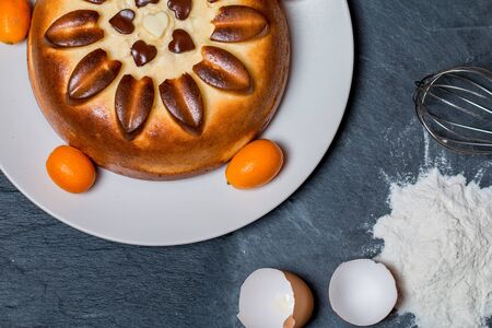cake on plate with ingredients flour, eggs on black stone backgroundの写真素材