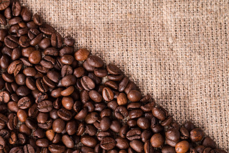 Coffee beans on burlap sack backgroundの写真素材