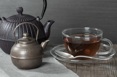 Cup of tea and a vintage teapot on wooden backgroundの写真素材