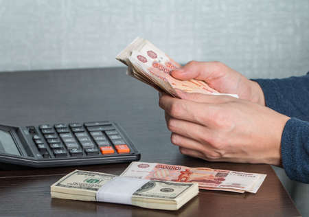 Man's hands with money and calculator. Money saving concept.の写真素材
