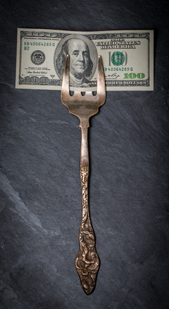 hundred dollars on old fork on black backgroundの写真素材