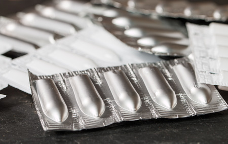 Different packages of suppository on black background