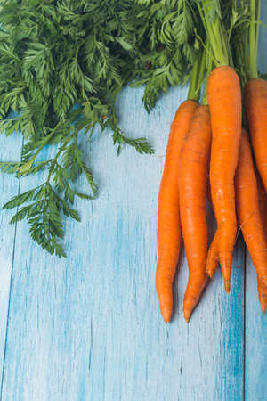 fresh carrots bunch on blue wooden background