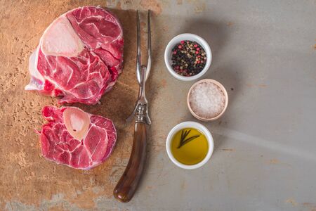 Raw fresh cross cut veal shank and seasonings for making Osso Buco on wooden backgroundの写真素材