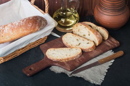Sliced bread Ciabatta and rosemary on wooden background