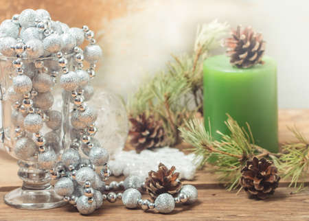 Christmas Composition with Gifts and candle, white balls, pine cones, snowflakes on wooden table. Toned.の写真素材