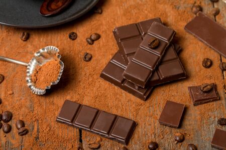 Cocoa Powder and Dark Chocolate on old wooden table