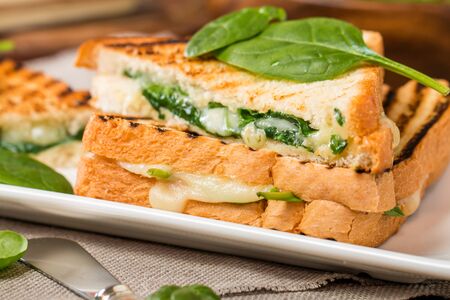 sandwich with cheese and spinach on wooden background, close upの写真素材
