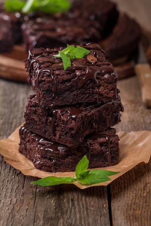 Delicious chocolate brownie with mint on wooden table.の写真素材