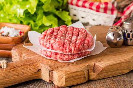 Ingredients for making homemade burger on wooden cutting boardの写真素材