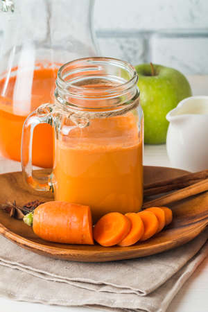Fresh carrot juice in a glass on white wood backgroundの写真素材