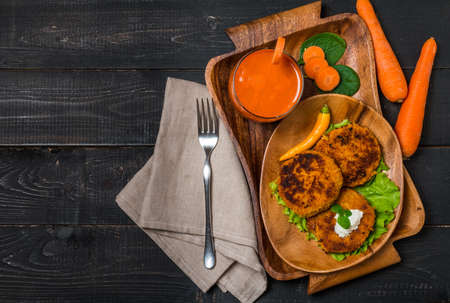 Healthy vegetarian carrots cutlets with carrot juice on  black wooden background, top viewの写真素材