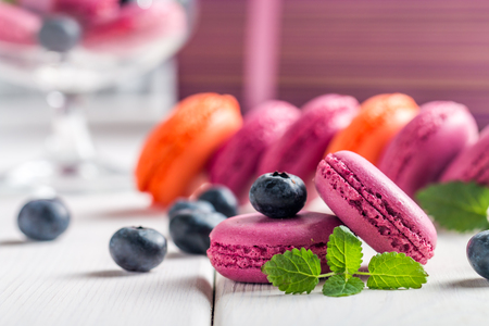 Violet macaroon with fresh  blueberries on white wooden backgroundの写真素材