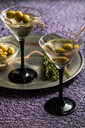 Two glasses of Dry Martini, classic cocktail with olives, vodka and gin served coldの写真素材
