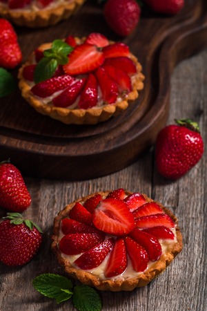 Fresh homemade strawberries tarts  on wooden backgroundの写真素材
