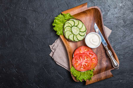 Vegetarian sandwiches with cream cheese and vegatables on black background, top viewの写真素材