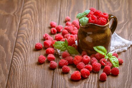 Fresh raspberry in a jug on wooden backgroundの写真素材