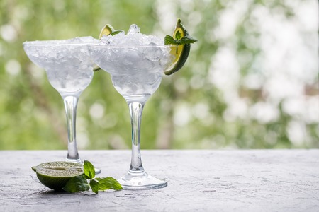 empty cocktail glass with ice on nature backgroundの写真素材