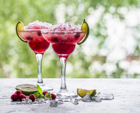 margarita cocktail with lime and raspberries on nature backgroundの写真素材