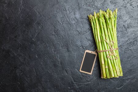 Asparagus with small chalk board on black background, top view, copy spaceの写真素材