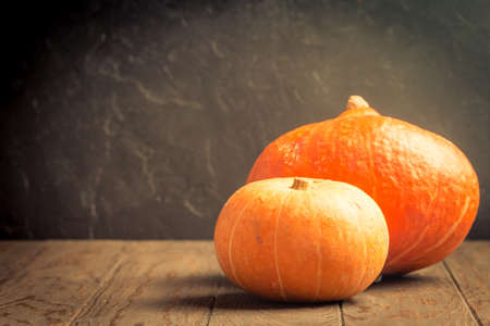 Autumn Pumpkins on dark wooden table, dark backgroundの写真素材