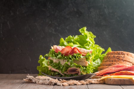Club sandwich on a rustic table with ingredientsの写真素材