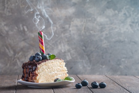 Piece of delicious sponge cake with cream and chocolate on plateの写真素材