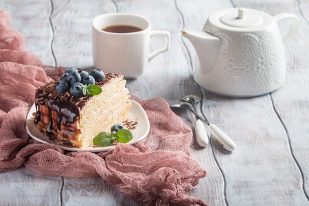 Piece of delicious sponge cake with cream and chocolate on plateの写真素材
