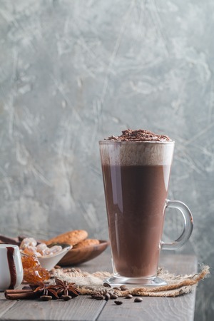 Coffee latte in a tall glass on the corner of wooden tableの写真素材