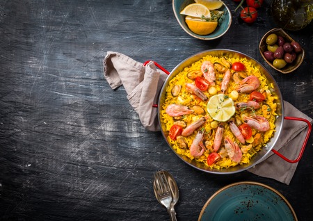 Traditional seafood paella in the fry pan on black background, top viewの写真素材