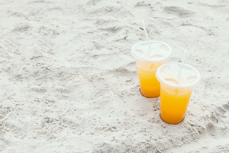 Orange juice in a glass on the beach. Summer concept.の写真素材