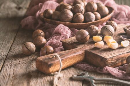 Macadamia nuts on cutting board over wooden tableの写真素材