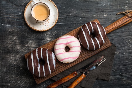 Donuts and coffee on black background. Top view with copy spaceの写真素材