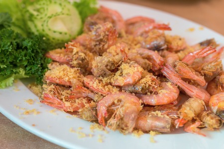 Close up shrimps cooked with garlic and dill on white plateの写真素材