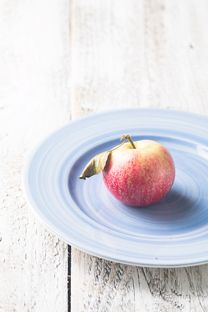 Ripe apple on blue plateの写真素材