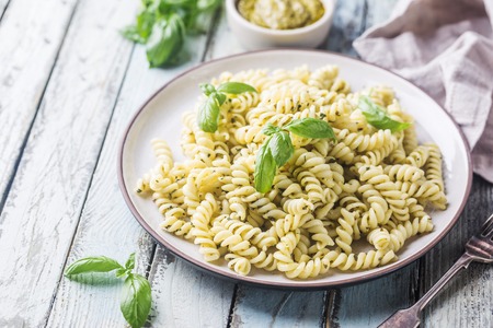 Italian fusilli pasta with fresh homemade pesto sauce on a plate over white wooden backgroundの写真素材