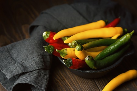 Fresh hot chilli pepper in a bowl on a rustic background.の写真素材