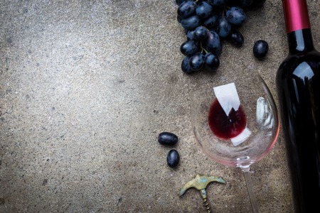 A bottle of red wine with grapesの写真素材