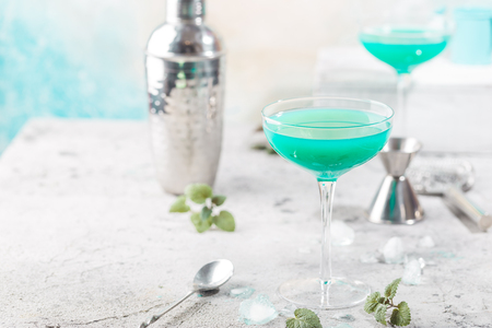 Colorful summer cocktail Blue Hawaii or iced   alcohol drink with mint on light stone backgroundの写真素材
