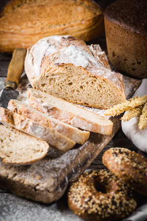 Fresh homemade slice bread and knife on rustic tableの写真素材
