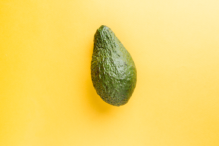 green whole avocado on yellowの写真素材