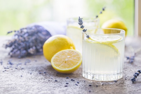 Lemonade with lemons and lavender on stone table over nature backgroundの写真素材